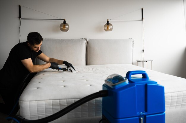 Cleaner using an extractor to deep clean couch stains and dust in a home.