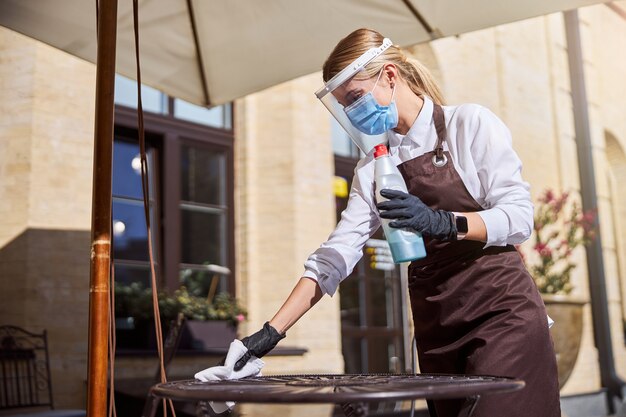 Professional cleaner preparing to clean an outdoor restaurant space, showcasing preparation for a thorough cleaning service in London