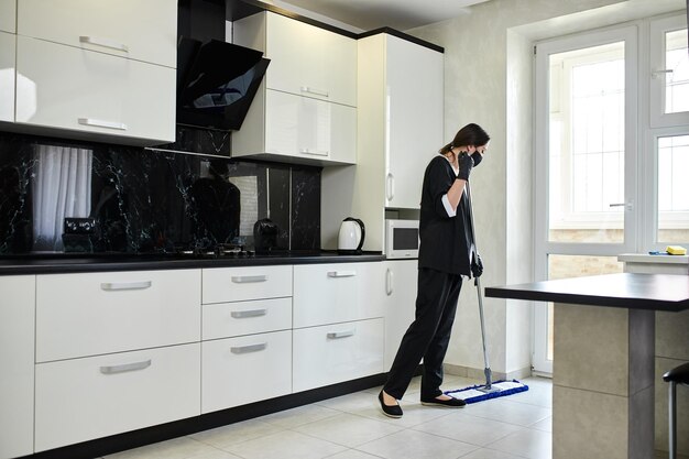 Kitchen deep cleaning in London with mop and rubber gloves