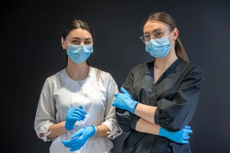 Two fully trained and masked professional cleaners in uniform ready to carry out a sanitisation clean in an East London home
